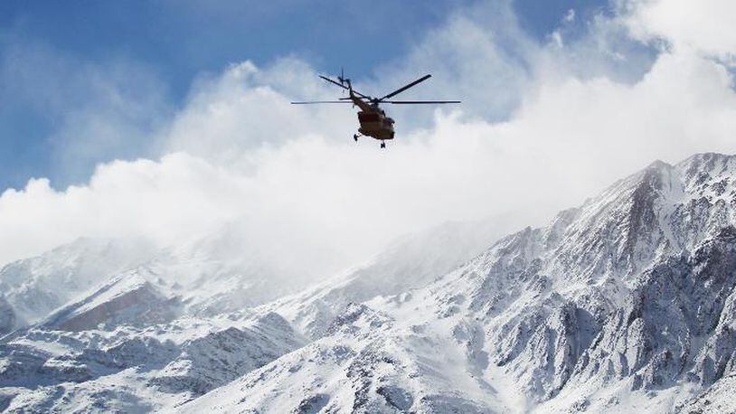 In this photo provided by Tasnim News Agency, a rescue helicopter flies over the Dena mountains while searching for wreckage of a plane that crashed on Sunday, in southern Iran, Monday, Feb. 19, 2018. (Ali Khodaei/Tasnim News Agency via AP)
