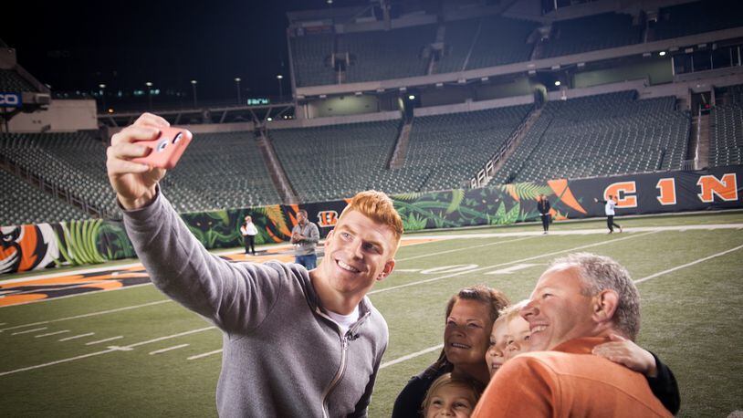 Cincinnati Bengals quarterback Andy Dalton takes a picture with some fans who attended his “Night in the Jungle” event that raised $30,000 for his foundation Thursday night.