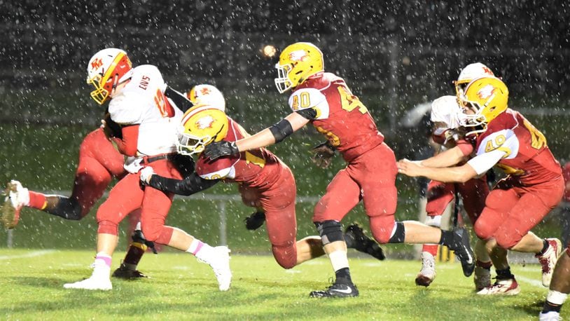 Fenwick’s Tyler Houck (19), Carter Earls (40) and Paul Bailey (49) go after Purcell Marian quarterback Zach Hoover (12) on Friday night at Krusling Field in Middletown. Fenwick won 31-14. CONTRIBUTED PHOTO BY ANGIE MOHRHAUS