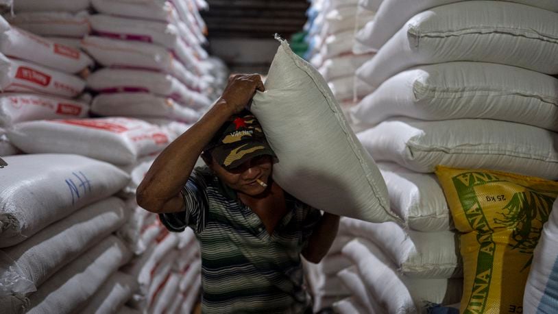 A worker carries a bag of rice at a warehouse in Ho Chi Minh City, Vietnam, Tuesday, Jan. 30, 2024. Vietnam is the world's third largest rice exporter, and the staple importance to Vietnamese culture is palpable in the Mekong Delta. (AP Photo/Jae C. Hong)