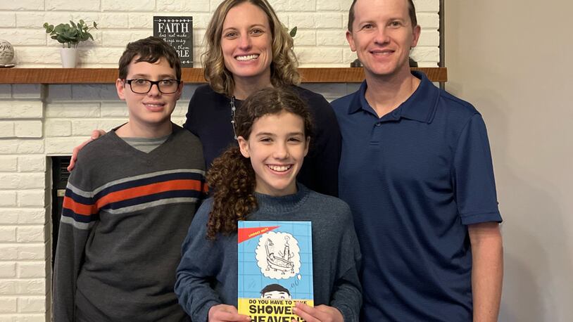 Local author Lindsey Hilty is seen with her family. her daughter is holding her book, "Do You Have To Take Showers in Heaven? And Other Kid Questions About Our Forever Home With God”. CONTRIBUTED