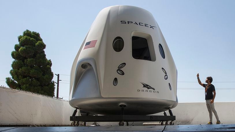A reporter takes a smart phone photo of a mock up of the Crew Dragon spacecraft during a media tour of SpaceX headquarters and rocket factory on August 13, 2018 (Photo by David McNew/Getty Images)