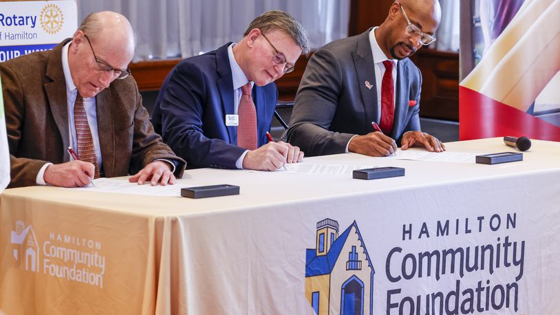 Hamilton Mayor Pat Moeller, left, John Guidugli, President and CEO of Hamilton Community Foundation, middle, and Ande Durojaiye, Dean of the College of Liberal Arts and Applied Science and Vice President of Miami Regional campuses, sign an agreement as Hamilton Community Foundation commits funding support to education as the launch of the Miami Regionals Hamilton Promise Scholarship program Thursday, Feb. 8, 2024 at Fitton Center for Creative Arts in Hamilton. NICK GRAHAM/STAFF