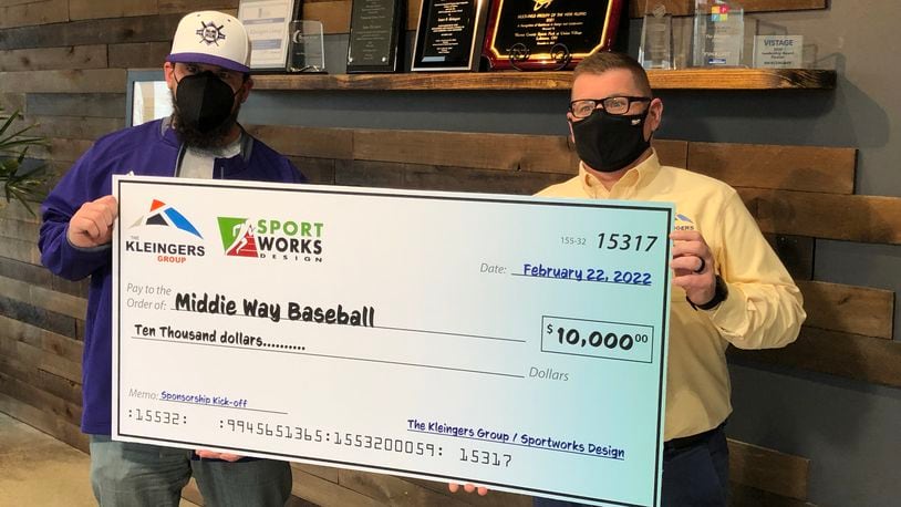 Tim Casto, right, president and CEO of The Kleingers Group, a civil engineering company based in West Chester, presents a $10,000 check to Kyle Schwarber, a Mddletown High School graduate and MLB player, Tuesday afternoon. The money will be used to purchase equipment for Middie Way Baseball. RICK McCRABB/STAFF