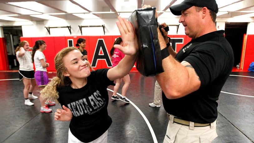 The cities of Fairfield and Hamilton police departments will co-teach a Rape Aggression Defense class at the Fairfield Community Arts Center next month. Pictured then-high school senior Jessica Wall and West Chester Police Officer Phil Chaney during a self-defense class held in May 2014 at Lakota East High School. STAFF FILE PHOTO