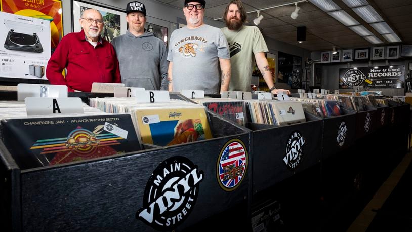 Left to right: Main Street Vinyl owner Bill Herren stands with Unsung Salvage Design Company owners Jason Carder, Dondi Carder and Justin Carder Thursday, March 3, 2022 in Hamilton. Herren is retiring and Unsung Salvage is buying the Main Street Vinyl business. NICK GRAHAM/STAFF