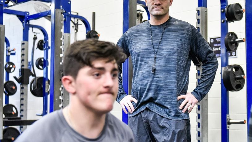 New Hamilton football coach Nate Mahon keeps his eyes on a Big Blue weight lifting session Thursday at the school. NICK GRAHAM/STAFF