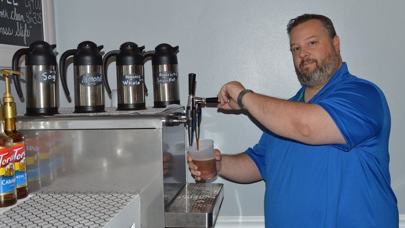 Dave Bryan draws a cup of Nitro Brew coffee at the recently-opened Dough-Versity Neighborhood Donut and Coffee Company, at 5 S. Beech St. CONTRIBUTED/BOB RATTERMAN