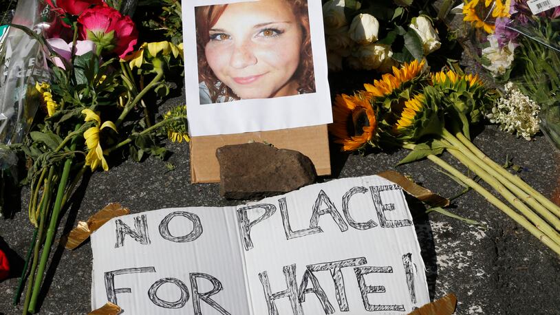 A makeshift memorial of flowers and a photo of victim, Heather Heyer, sits in Charlottesville, Va., Sunday, Aug. 13, 2017. Heyer died when a car rammed into a group of people who were protesting the presence of white supremacists who had gathered in the city for a rally. (AP Photo/Steve Helber)