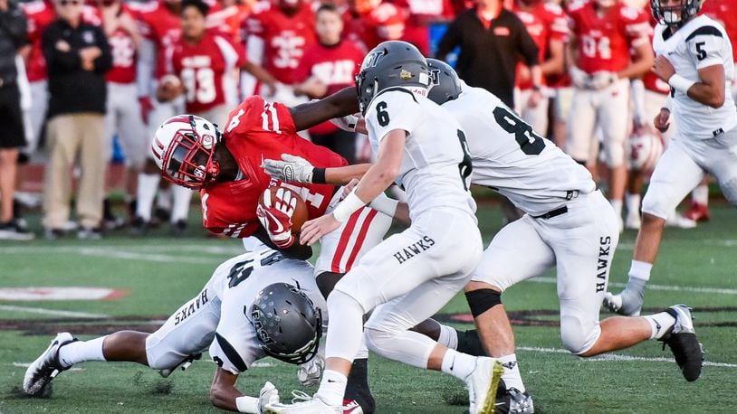 Lakota East’s Avi McGary (23) and Jackson Leahy (6) are among the players tackling Lakota West’s David Afari during a Sept. 29 game in West Chester Township. East won 35-0. NICK GRAHAM/STAFF