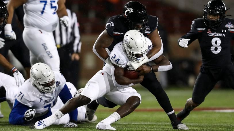 Cincinnati defensive end Malik Vann (42) tackles Tulsa running back Corey Taylor II (24) as he carries the ball during the first half of the American Athletic Conference championship NCAA college football game, Saturday, Dec. 19, 2020, in Cincinnati. (AP Photo/Aaron Doster)