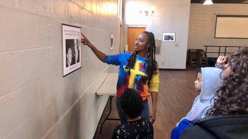 Marie Edwards, director of the Out of School Program at Community Building Institute in Middletown, talks to some students about Martin Luther King Jr.'s message as part of the Middletown Freedom Tour at the Robert "Sonny" Hill Jr. Community Center. RICK McCRABB/STAFF