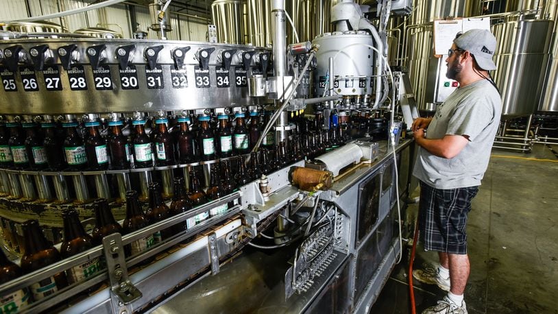 Rivertown Brewery owner Jason Roeper works the filling line at Rivertown Brewery & Barrel House Wednesday, June 14 in Monroe. NICK GRAHAM/STAFF