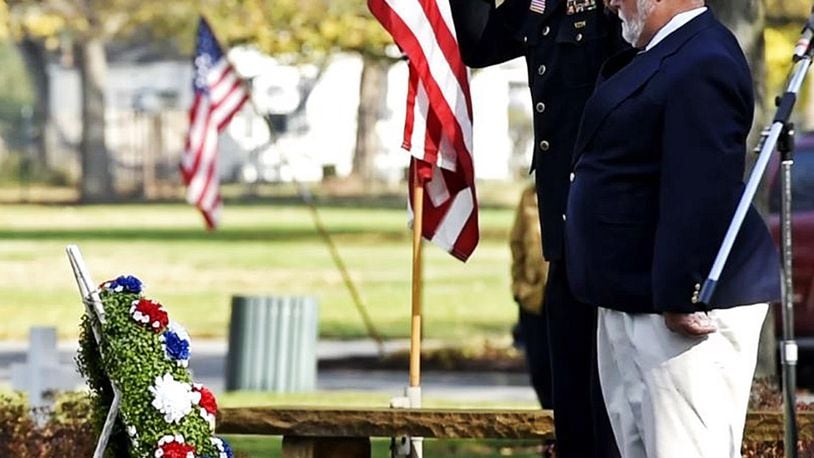 American Legion Post 218 Commander Mike Gomia, right, and Mark Singh, VFW Post 3809 Commander, salute after placing a wreath on the World War II memorial during the Veterans Day ceremony last year at Woodside Cemetery and Arboretum in Middletown. NICK GRAHAM/STAFF FILE