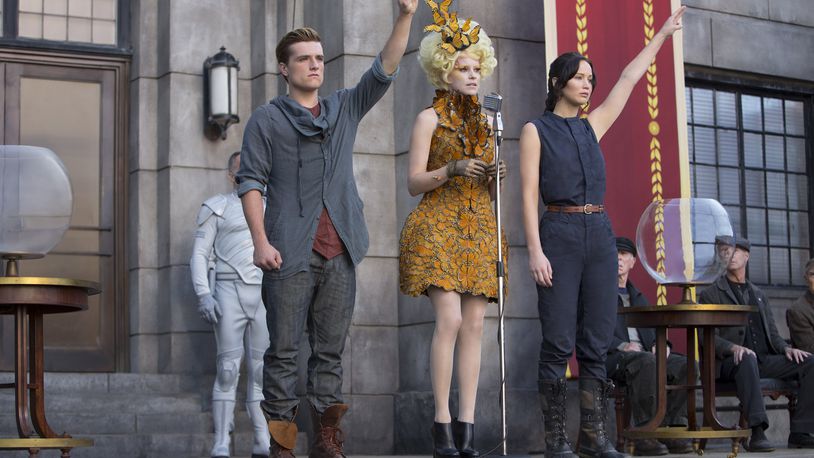 Katniss Everdeen (Jennifer Lawrence, right), Effie Trinket (Elizabeth Banks, center) and Peeta Mellark (Josh Hutcherson, left) in “The Hunger Games: Catching Fire.” Photo Credit: Murray Close