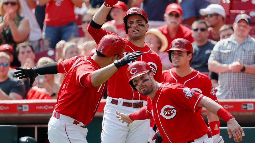 Cincinnati Reds’ Eugenio Suarez, left, celebrates with Jesse Winker, right, after hitting a two-run home run off Pittsburgh Pirates starting pitcher Gerrit Cole in the sixth inning of a baseball game, Sunday, Sept. 17, 2017, in Cincinnati. (AP Photo/John Minchillo)