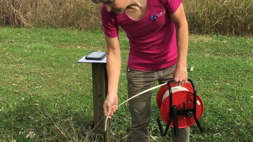 Elli Sigmond, a hydro technician at the Miami Conservancy District, does a groundwater measurement at an observation well in Hamilton County. The well is one of many in the region that the MCD uses to track changes in groundwater storage each month. CONTRIBUTED