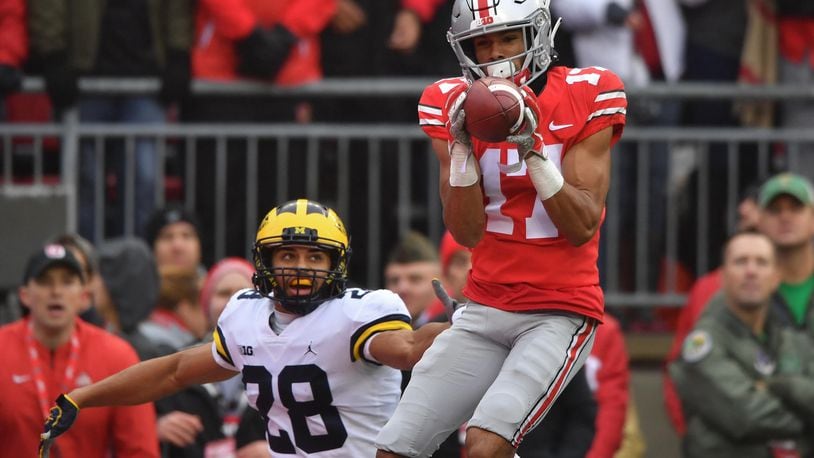 COLUMBUS, OH - NOVEMBER 24: Chris Olave #17 of the Ohio State Buckeyes catches a 24-yard touchdown pass in the second quarter in front of Brandon Watson #28 of the Michigan Wolverines at Ohio Stadium on November 24, 2018 in Columbus, Ohio. (Photo by Jamie Sabau/Getty Images)