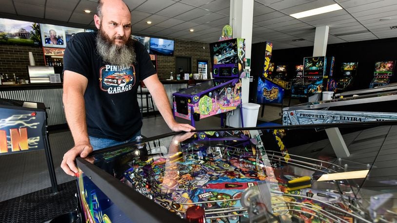 Pinball Garage owner Brad Baker plays the brand new Teenage Mutant Ninja Turtles pinball game Thursday, June 25, 2020. Pinball Garage is now open in downtown Hamilton and offers a large selection of pinball machines to play along with a bar with rotating beer selection. NICK GRAHAM / STAFF