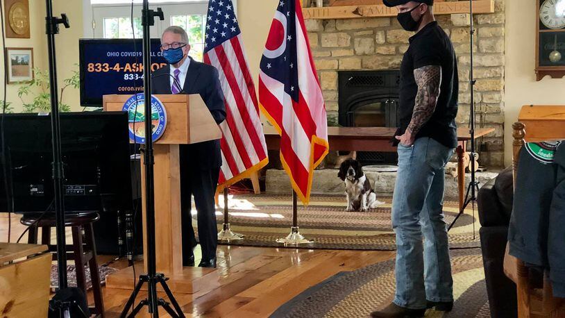 Gov. Mike DeWine and videographer Eric Porter get ready for a coronavirus press briefing to be broadcast from DeWine's Greene County farm. First Dog Dolly looks on.