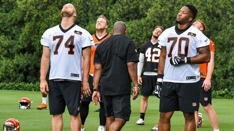 Bengals’ offensive tackles Jake Fisher (74) and Cedric Ogbuehi (70) stretch during organized team activities Tuesday, May 22 at the practice facility near Paul Brown Stadium in Cincinnati. NICK GRAHAM/STAFF