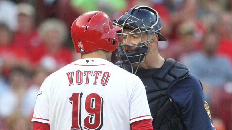 The Reds' Joey Votto argues with the Brewers' Erik Kratz in the third inning on Thursday, June 28, 2018, at Great American Ball Park in Cincinnati.
