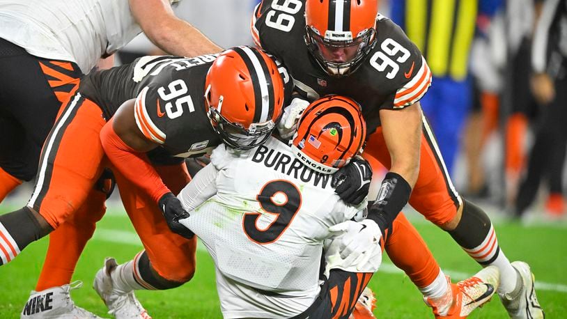 Cincinnati Bengals quarterback Joe Burrow (9) is sacked by Cleveland Browns defensive end Myles Garrett (95) and Taven Bryan (99) during the second half of an NFL football game in Cleveland, Monday, Oct. 31, 2022. (AP Photo/David Richard)