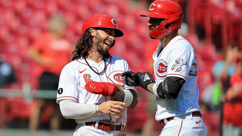 Cincinnati Reds' Nick Castellanos, right, celebrates hitting a three-run home run with Jonathan India during the sixth inning of a baseball game against the Pittsburgh Pirates in Cincinnati, Monday, Sept. 27, 2021. (AP Photo/Aaron Doster)