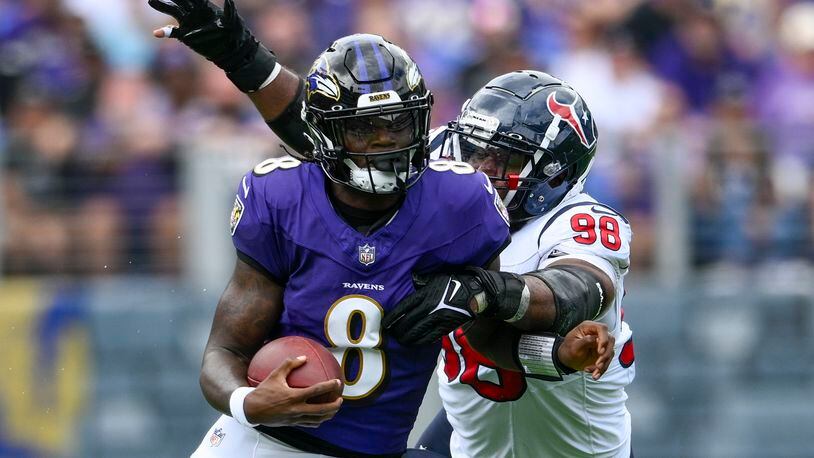 Baltimore Ravens' Lamar Jackson runs past Houston Texans' Sheldon Rankins during the first half of an NFL football game Sunday, Sept. 10, 2023, in Baltimore. (AP Photo/Nick Wass)