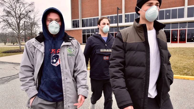 Miami students, left to right, Brian Coan, Matt Reinberg and Jack Kulick wear face masks as they walk across campus Tuesday, Jan. 28, 2020, in Oxford. NICK GRAHAM / STAFF