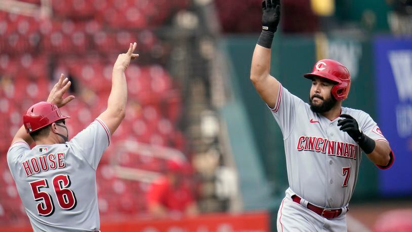 Cincinnati Reds' Eugenio Suarez (7) celebrates with third base coach J.R. House while rounding the bases after hitting a solo home run during the eighth inning of a baseball game against the St. Louis Cardinals Sunday, Sept. 13, 2020, in St. Louis. (AP Photo/Jeff Roberson)