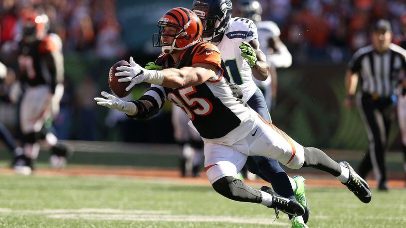 CINCINNATI, OH - OCTOBER 11: Tyler Eifert #85 of the Cincinnati Bengals dives to make a catch while being defended by Kam Chancellor #31 of the Seattle Seahawks during overtime at Paul Brown Stadium on October 11, 2015 in Cincinnati, Ohio. Cincinnati defeated Seattle 27-24 in overtime. (Photo by Andy Lyons/Getty Images)