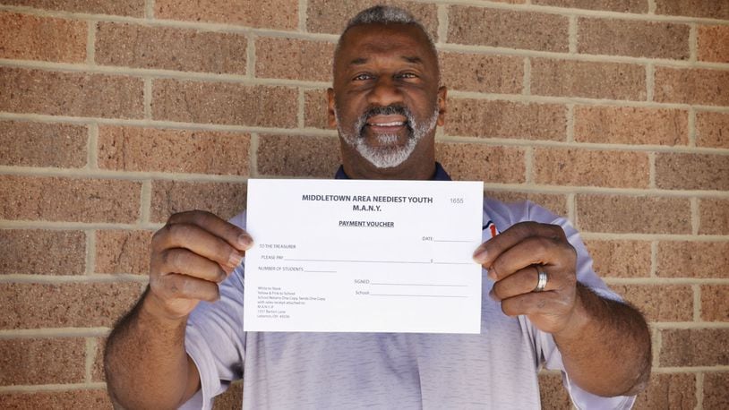 Chuck Hall, principal at Marshall High School in Middletown, shows one of the vouchers the school uses when students need to purchase clothes as part of the Middletown Area Neediest Youth (MANY) program. NICK GRAHAM/STAFF