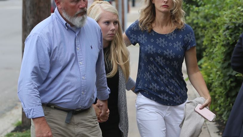Brooke Skylar Richardson, center, is escorted by her parents Friday into Franklin Municipal Court for an arraignment hearing on a charge of reckless homicide in connection to the death of her baby. The baby’s remains were found buried in the backyard of her home. GREG LYNCH/STAFF