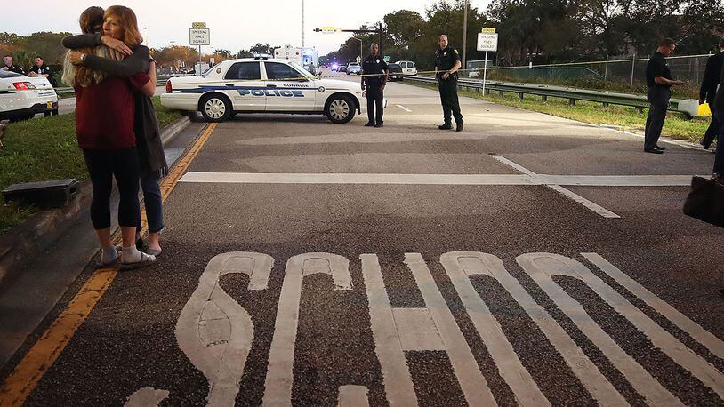 PARKLAND, FL - FEBRUARY 15: Kristi Gilroy (R), hugs a young woman at a police check point near the Marjory Stoneman Douglas High School where 17 people were killed by a gunman on February 15, 2018 in Parkland, Florida. A wide-spread statistic claiming the shooting was the 18th this year is misleading. (Photo by Mark Wilson/Getty Images)