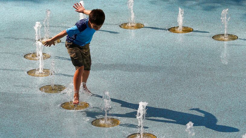 One person uses the CityScape splash pad to stay cool as temperatures climb to near-record highs Tuesday, June 20, 2017, in Phoenix. The National Weather Service forecasts a high of 120 degrees (49 degrees Celsius), which is has only hit three times in recorded history in Phoenix, the last time 22 years ago. (AP Photo/Ross D. Franklin)