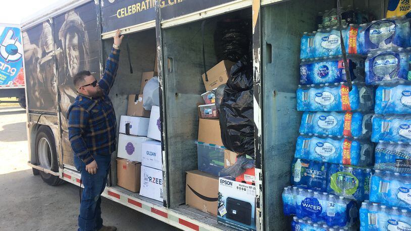 Kyle Greene closes a semi trailer filled with donated water, food, clothes and other items that will be distributed to those impacted by tornado devastation in Kentucky. Hasan Karim/ Staff