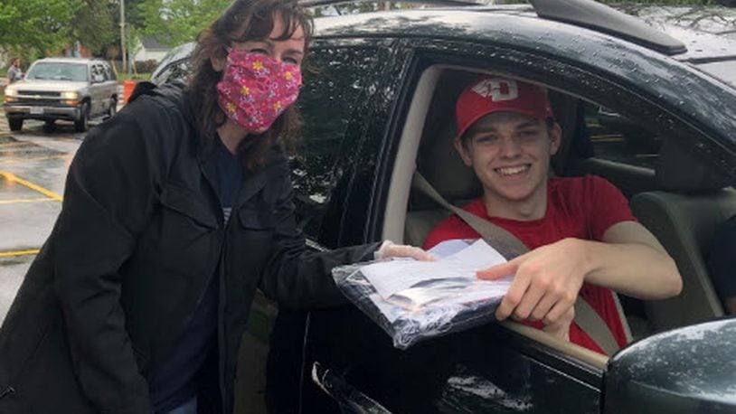 In May, Kettering Fairmont teachers, including Christina Martin here, passed out caps and gowns to the seniors they had in homeroom the past four years, like Matt Pennington (in car). CONTRIBUTED PHOTO