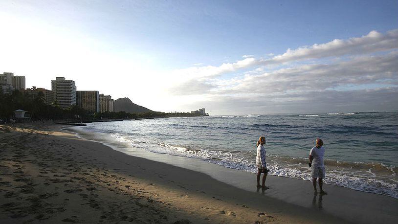 Vacationers walk along Waikiki Beach Feb. 27, 2010, in Honolulu, Hawaii.