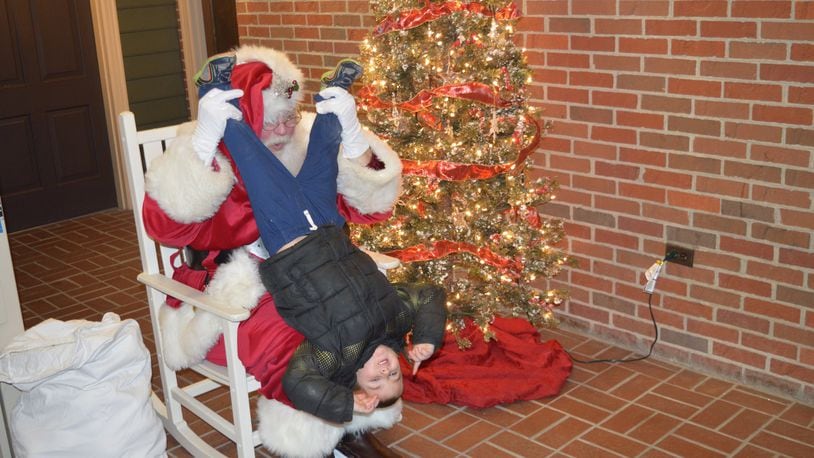 Scott Shriver, who is known as Santa Ray Scott, knows how to make a child’s visit with Santa a memorable one, even if it means being silly and giving him an upside-down view of the world. CONTRIBUTED/BOB RATTERMAN