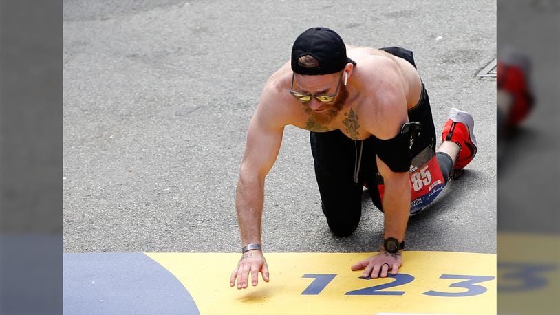 Micah Herndon crawls down Boylston Street towards the finish line of the 123rd Boston Marathon in Boston on April 15, 2019.