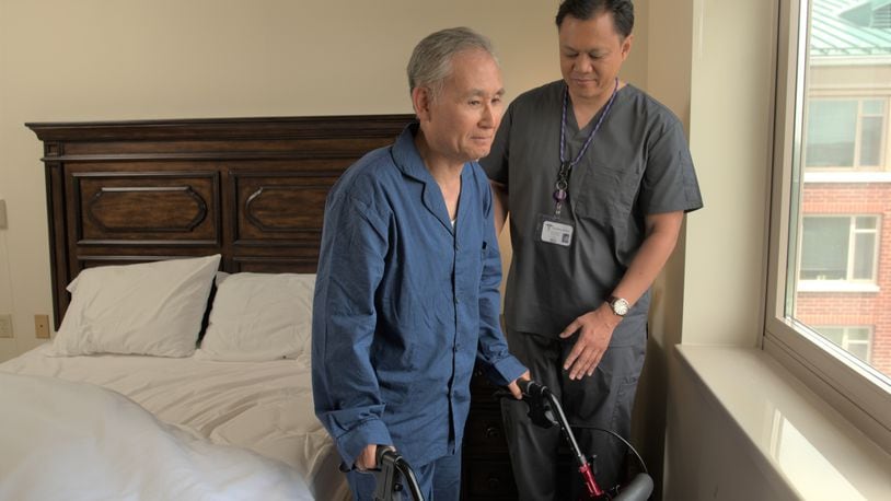 A direct care worker helps a patient in his home. COURTESY OF THE ALZHEIMER'S ASSOCIATION