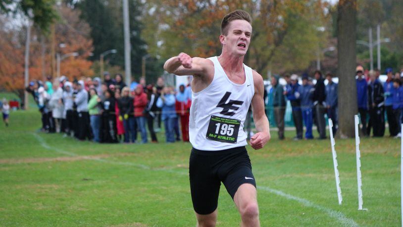 Lakota East’s Dustin Horter pumps his fist as he wins the Division I regional boys cross country championship Saturday in Troy. CONTRIBUTED PHOTO BY GREG BILLING