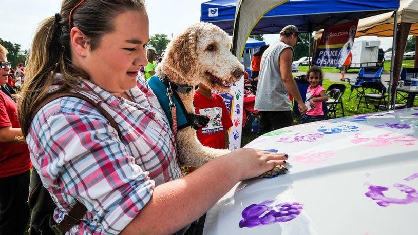 Emma McClung, 15, puts Sadie’s paw print on a Middletown Division of Police cruiser during Middletown’s National Night Out this past summer. Middletown City Council will soon give consideration for future improvements at Miami Park that include a new dog park.