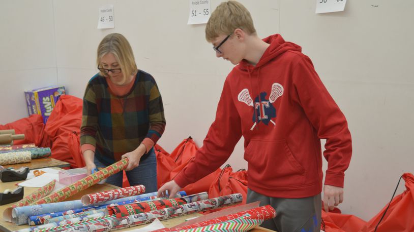 Gunnar Von Bergen, a Talawanda High School freshman, joined his mother, Erin, helping to wrap gifts for Miami s Holiday Project. Erin Von Bergen works at Miami and said while she was growing up, her mother was a CASA volunteer. CONTRIBUTED/BOB RATTERMAN