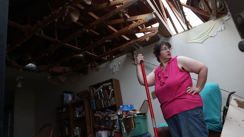 Amanda Logsdon begins the process of trying to clean up her home after the roof was blown off by the passing winds of Hurricane Michael. There are a number of ways to help hurricane victims.