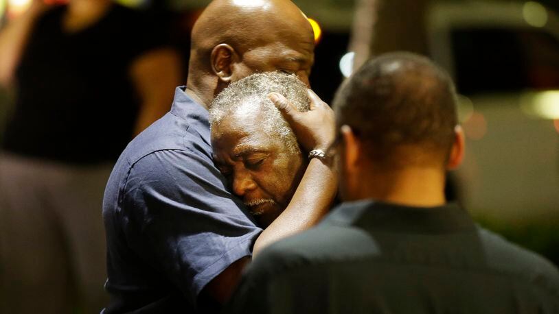 Worshippers embrace following a group prayer across the street from the scene of a shooting June 17, 2015, in Charleston, S.C.