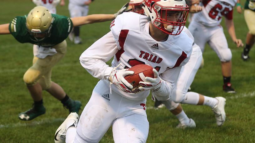Triad’s Isaiah Bruce carries the ball after making a reception against Catholic Central. BILL LACKEY/STAFF