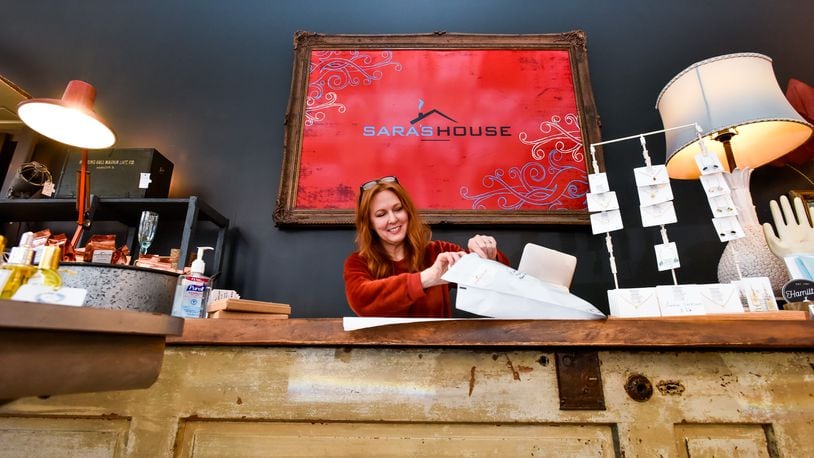 FILE: Sara Vallandingham, owner of Sara's House in downtown Hamilton, packs up an online order for shipment Wednesday, March 18, 2020. NICK GRAHAM / STAFF