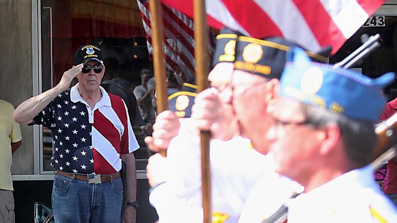 A veteran salutes as an Honor Guard carries the flag past during the 2016 Memorial Day parade in Hamilton.